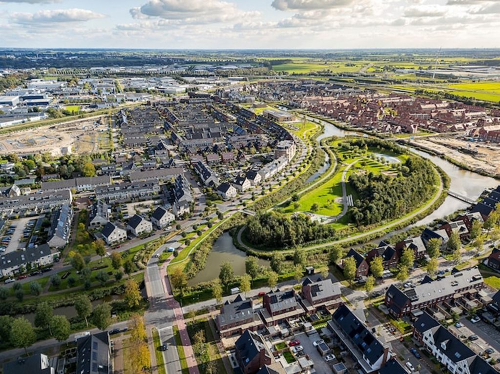 luchtfoto met huizen en groen en water in park Triangel