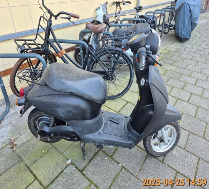 zwarte scooter zonder kenteken in een fietsenstalling