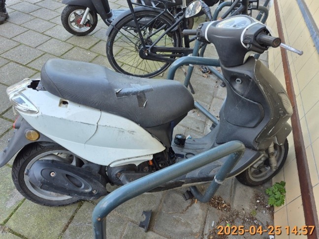 Zwart witte scooter zonder kenteken die geparkeerd staat aan de Vondellaan.