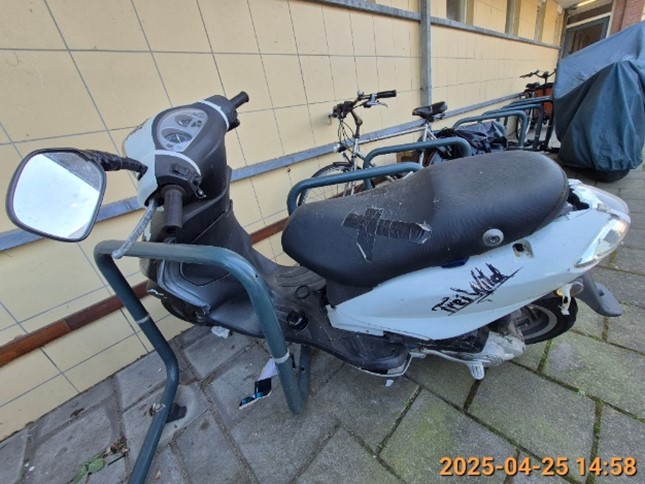 Zwart witte scooter zonder kenteken die geparkeerd staat aan de Vondellaan.
