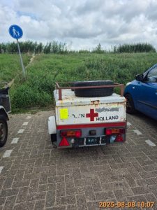 verwaarloosde wit met rode aanhanger zonder kenteken aan de Nic. Beetslaan, vlakbij nummer 168 op de parkeerplaats. Op de aanhanger liggen twee wielen.