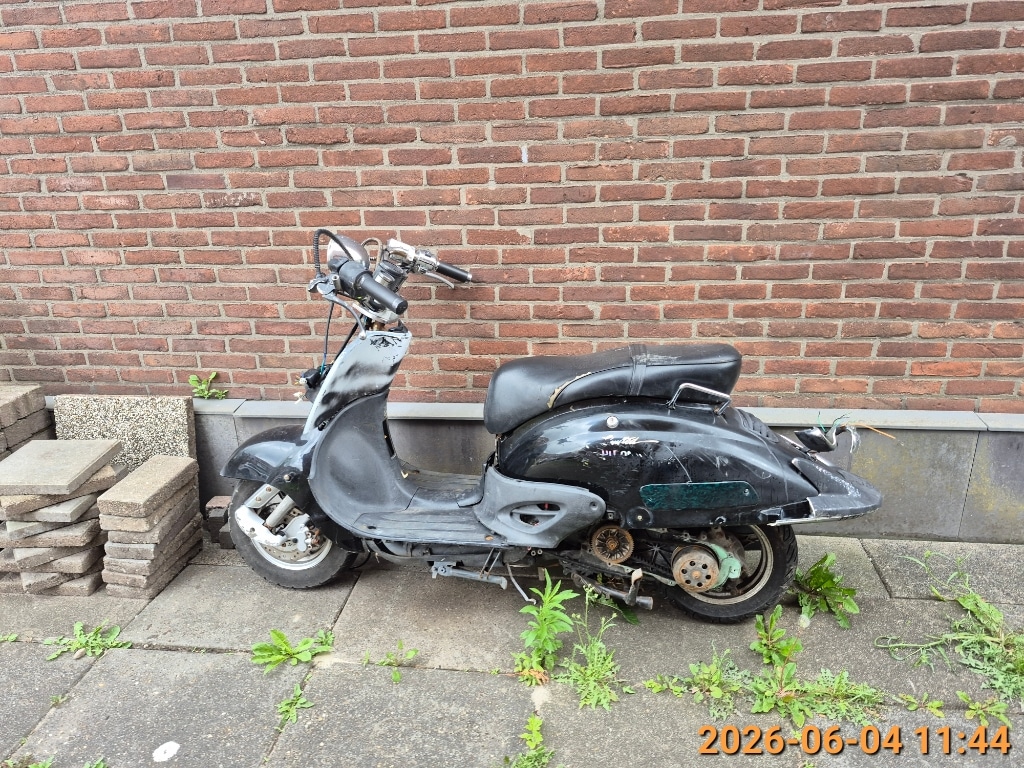 Scooterwrak zonder kenteken aan de Acaciastraat. 