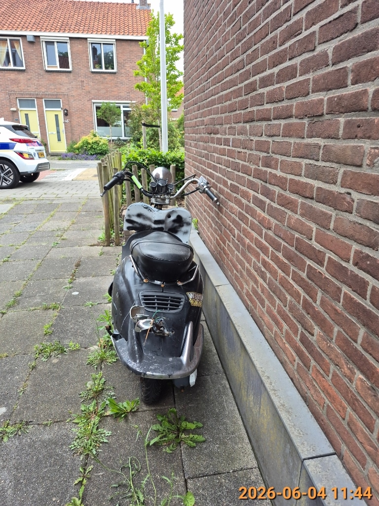 Scooterwrak zonder kenteken aan de Acaciastraat. 