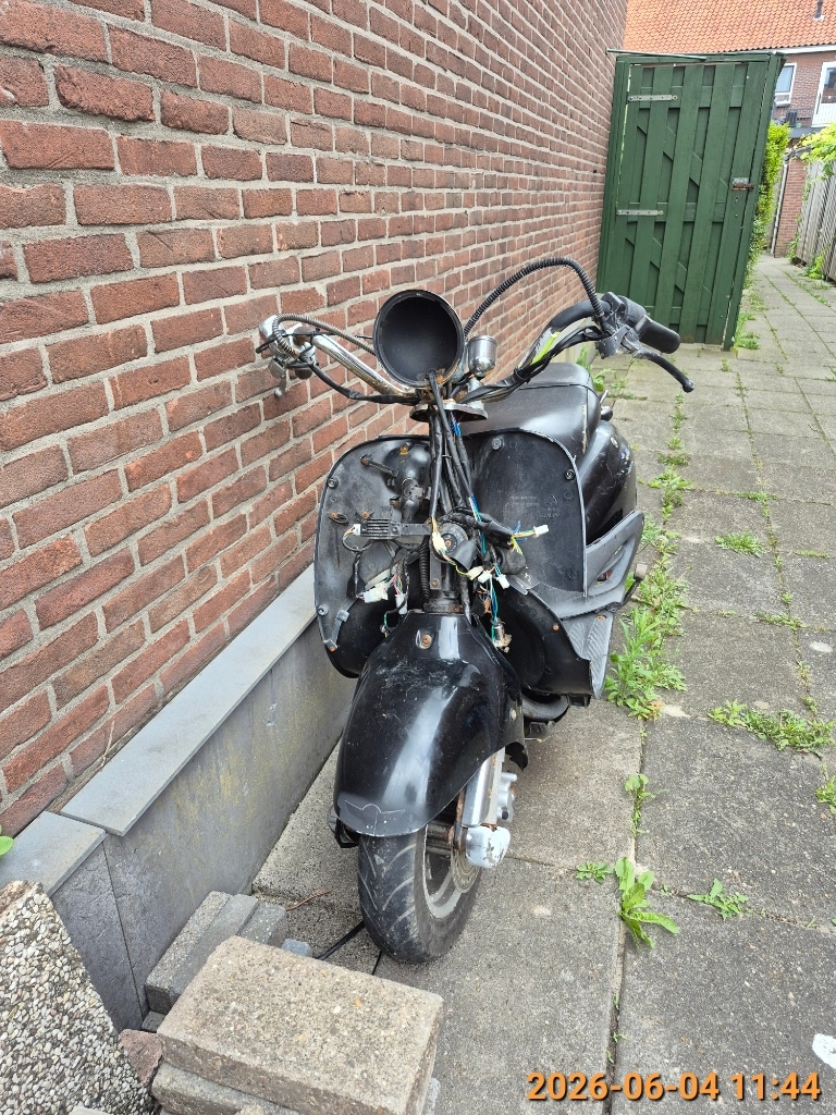 Scooterwrak zonder kenteken aan de Acaciastraat. 